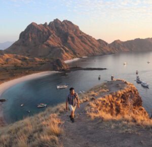 This is image of a man walking on hill near komodo island coast
