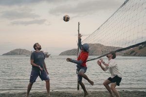 three-people-play-volleyball-at-beach