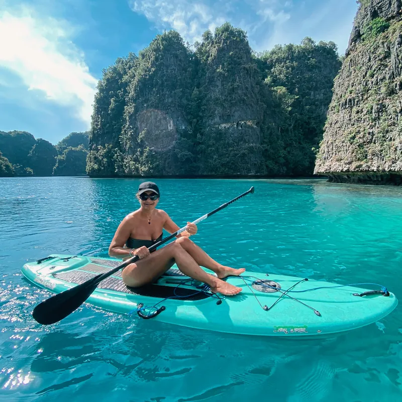 Un client sur une planche à pagaie Teman dans le lagon de Misool