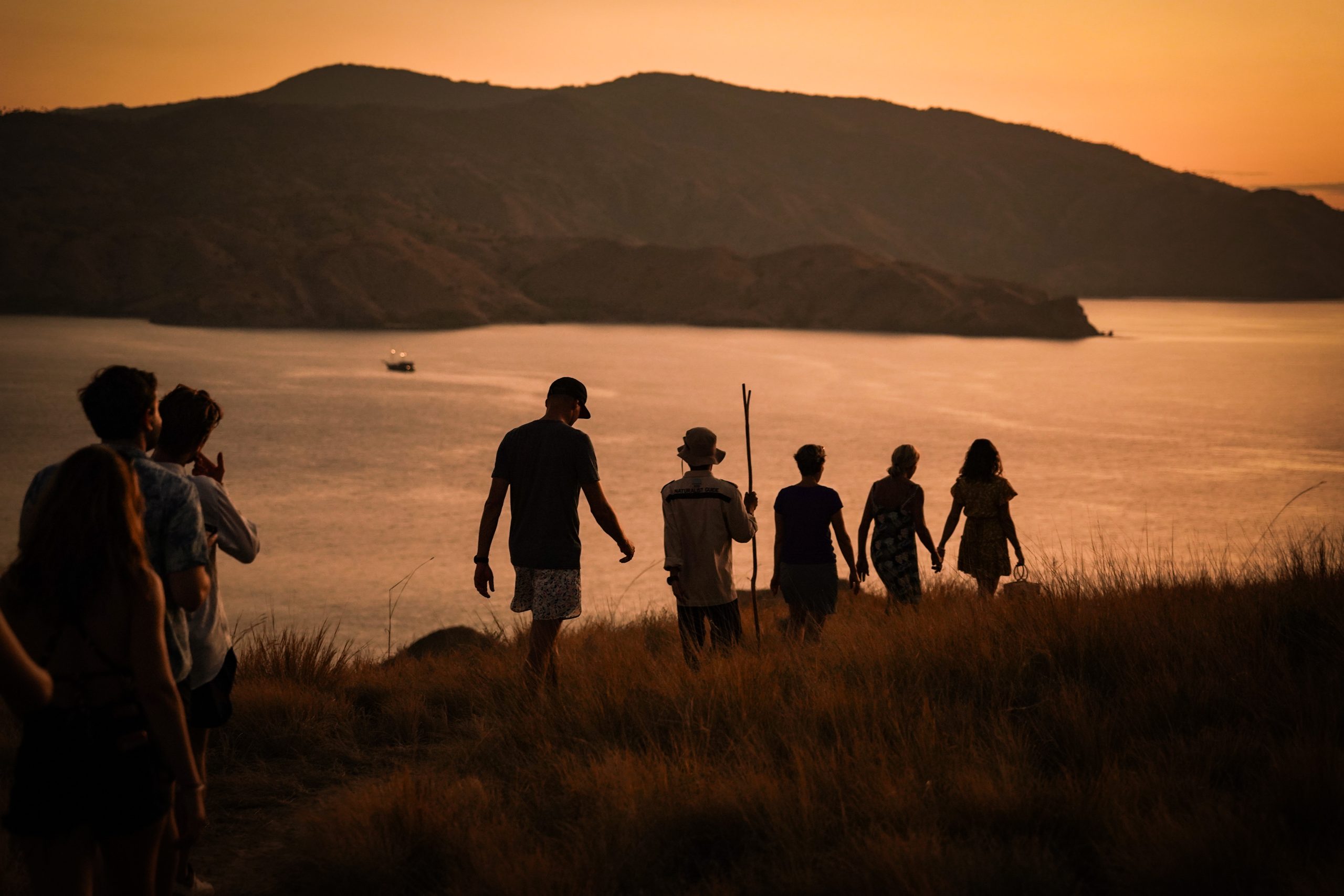 people trekking in sunset